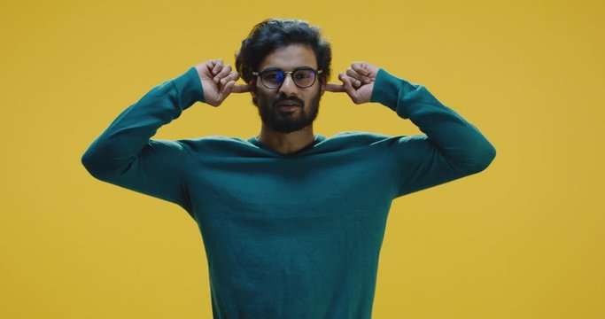 Young man plugging his ears