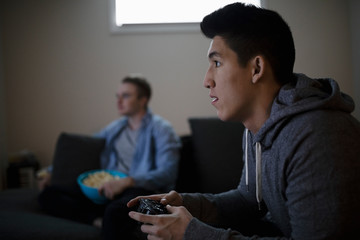 Focused young man playing video game