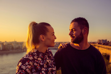 romantic couple at sunset. Smiling couple is enjoying sunset