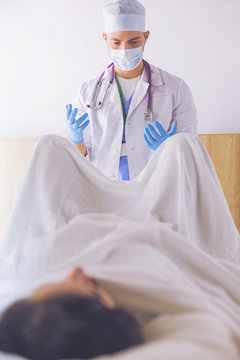 Male Obstetrician And Scrubs Nurse Are Delivered To The Pregnant Woman In The Delivery Room Of The Hospital