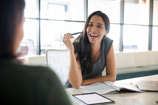 Businesswoman in meeting with colleague smiling