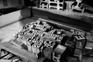 Primo piano di oggetti, lettere e blocchi di stampa di tipo metallico di una vecchia tipografia, foto in bianco e nero