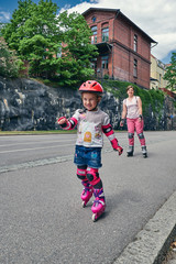 Young mother with her daughter on roller skates