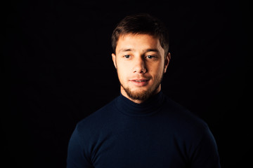 Fototapeta premium young man close-up portrait, on a black background