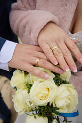 Obraz na płótnie Canvas Brautpaar mit goldenen Eheringen und Brautstrauß mit weißen Rosen