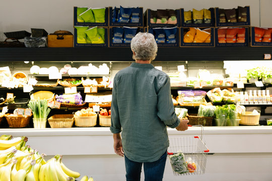 Senior man shopping for produce in grocery store