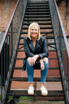 Portrait confident senior woman sitting on urban stairs