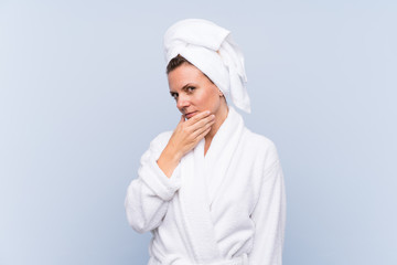 Woman in bathrobe over isolated blue background thinking an idea