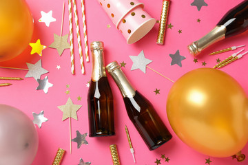 Composition with champagne and birthday accessories on pink background, top view