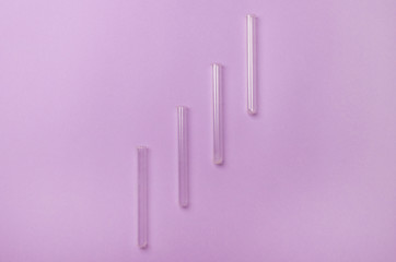 four test tube lying on diagonal on purple colored background
