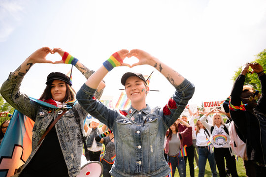Students making heart shapes with hands at gay pride parade