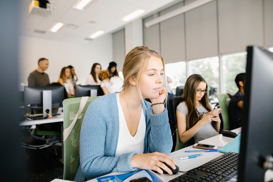 Female University Student Using Desktop Pc And Concentrating