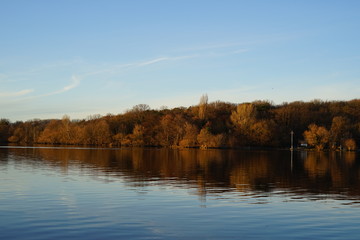 Fototapeta na wymiar Idyllische Flusslandschaft mit Haus und Bäumen in der Abendsonne