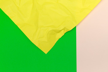 Colourful geometric paper background made with crumpled yellow, green and beige papers.