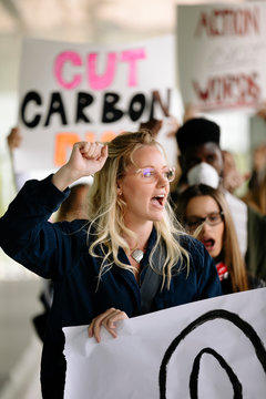 Student holding poster and chanting against climate change