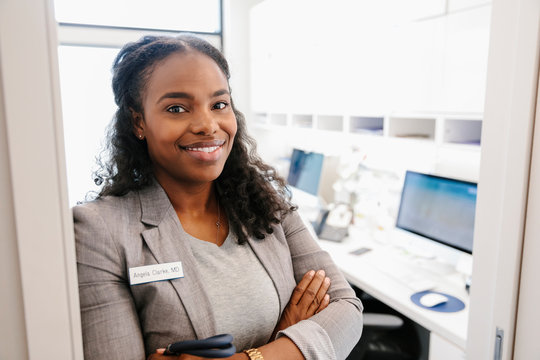 Portrait Smiling, Confident Female Doctor In Clinic Doorway