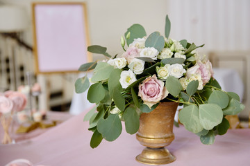 Beautiful floral arrangement of roses and greenery on wedding table in restaurant, copy space. Luxury wedding decorations. Table setting