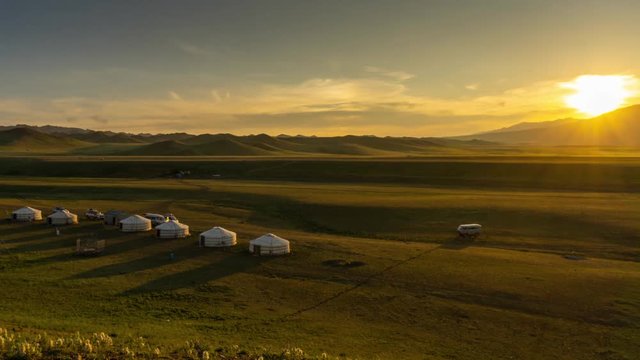 Landscape with traditional yurts and mountains at sunset, Mongolia, zoom out timelapse 4k