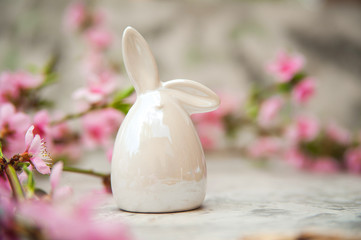 Spring photo of a blossoming tree and Easter eggs close-up and copy space. Easter card concept with bunny and eggs. Trending pink shades.