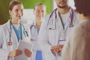 Doctors using a tablet in hospital standing in office