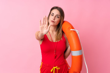 Lifeguard woman over isolated background making stop gesture with her hand