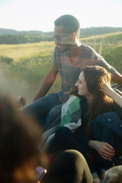 Young Couple Camping With Friends In Sunlight