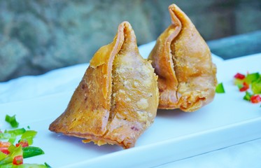 A platter with crispy vegetable samosa turnovers at an Indian restaurant