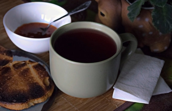 big cup of tea breakfast with toast and jam in Russian on wooden background