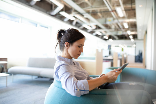 Businesswoman using digital tablet in open plan office