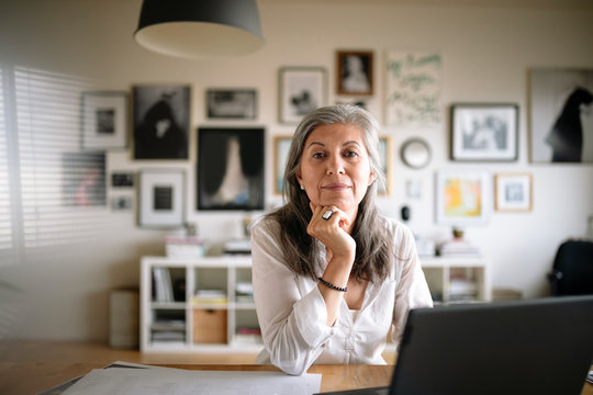 Portrait confident creative businesswoman working at laptop