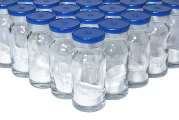 Glass medical vials with white powder vaccine