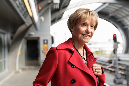 Senior woman waiting on railway platform and smiling