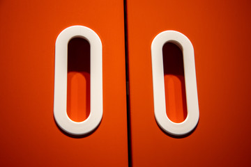 closeup detail of recessed white oval door handles red woodwork