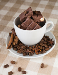 still life, installation, a cup with chocolate, coffee beans, anise and cinnamon sticks on a table
