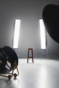 fan, reflector, wooden stool and lights on backstage in photo studio