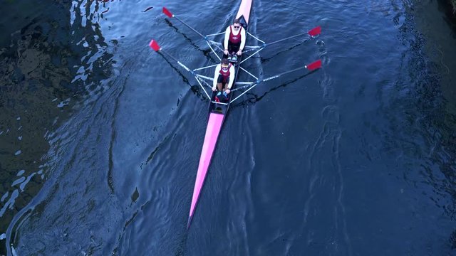 Rowboat with unrecognizable rowers seen from above.