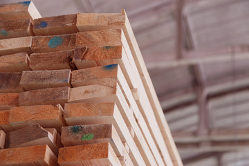 Warehouse or factory for sawing boards on sawmill indoors. Wood timber stack of wooden blanks construction material. Logging Industry.