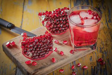 pomegranate and glass of pomegranate juice on wooden background