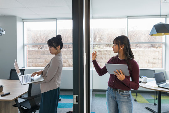 Split View Of Two Young Women Working In Modern Office