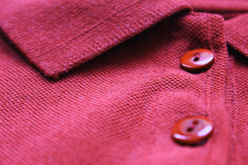 Polo shirt buttons and collar neck close up of purple or dark pink color clothes. Casual cotton...