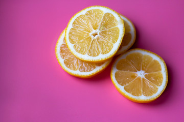 Flat lay composition with yellow lemons and space for text on color pink background.