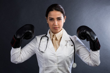 Medico donna in camice con i guantoni in mano fìdichiara guerra alle malattie - isolata su sfondo...
