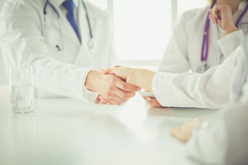 Doctor shaking hands with a male patient in the office