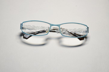 Optics. The medicine. On a white background, women's glasses with transparent lenses in a blue...