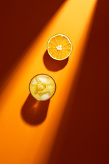 Glass of orange juice and sliced orange in sunlight. Cold summer cocktail