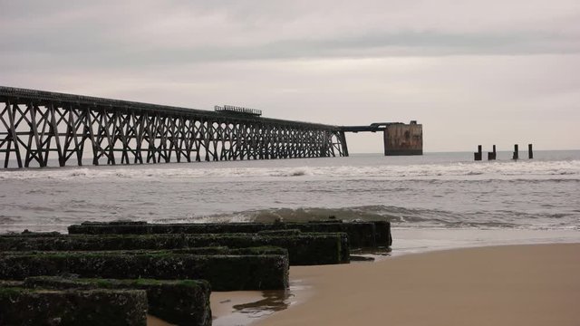 Long unused industrial pier during an overcast day.