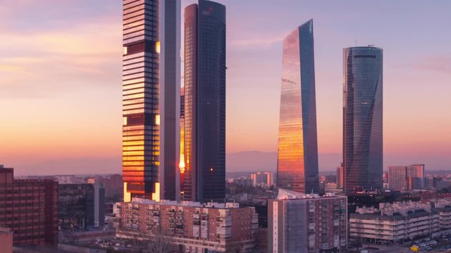 Unveiling close up time lapse of the Four skyscrapers in Madrid, Spain. Beautiful sunset and skyscrapers travelling up camera.