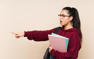 Young student Asian girl woman over isolated background pointing finger to the side