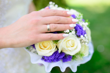 Obraz na płótnie Canvas Hands and rings on wedding bouquet. wedding theme