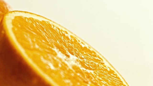 Two fresh oranges on a plate, macro panning shot, one orange sliced.4k